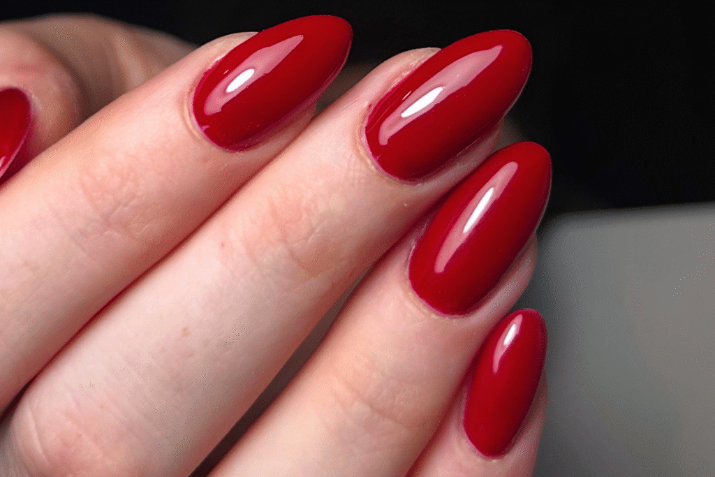 Elegante full colour rode nagels in amandelvorm, verzorgd met Level 1 nail art bij House of Elegance in Antwerpen.